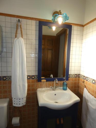 un bagno con lavandino e specchio di El Refugio de Hugo a Benablón