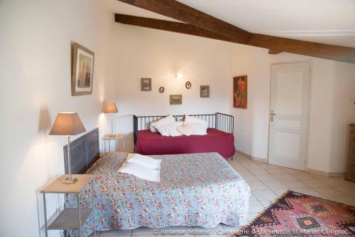 um quarto com uma cama e uma mesa com um candeeiro em Campagne de la source St Martin B&B em Cotignac