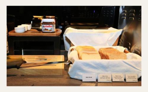 een tafel met twee sandwiches en pindakaas en een tafel met bij CUBE Boutique Capsule Hotel at Chinatown in Singapore