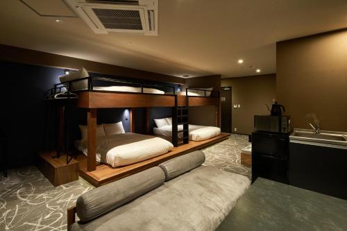 a bedroom with two bunk beds and a couch at B/C HOTEL NAHA Hotel with Rental Car in Naha