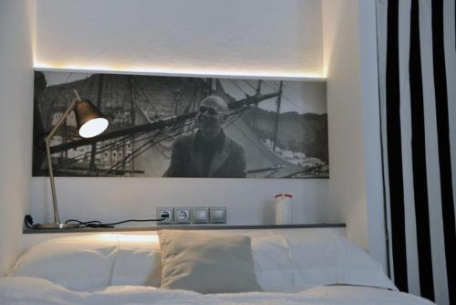 a picture of a man is above a bed at Hydra Icons in Hydra