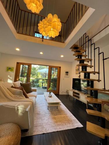 ein Wohnzimmer mit Sofa und Tisch in der Unterkunft Topanga Garden Paradise 1BR - in the Heart of PO Tract in Topanga