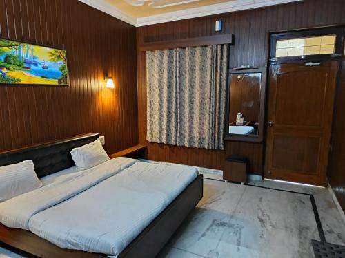 een slaapkamer met een groot bed en een badkamer bij Satkar palace hotel 