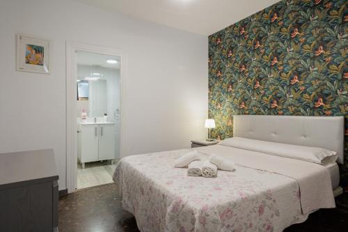 een slaapkamer met een groot bed met bloemenbehang bij Center Sevilla Magdalena Premium in Sevilla