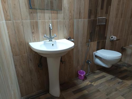 een badkamer met een wastafel en een toilet bij Satkar palace hotel 