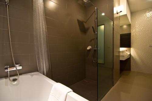 Un baño con ducha, bañera y lavabo. en Hotel J Residence Pattaya, en Pattaya central