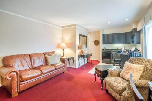 a living room with a couch and a kitchen at The Century House Latham - North Albany, an Ascend Collection Hotel in Latham