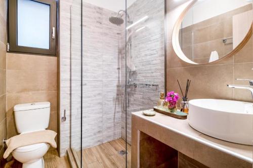 een badkamer met een toilet, een wastafel en een douche bij Ionian Sea View Luxury Apartments in Nikiana