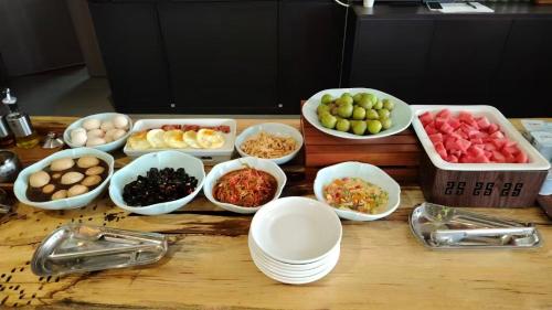 einen Tisch mit Schalen verschiedener Arten von Lebensmitteln in der Unterkunft Xunmiri Qinin Villa in Guiyang
