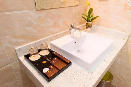 ein Badezimmer mit einem weißen Waschbecken und einer Ablage in der Unterkunft Kim Bao Hotel in Hải Dương