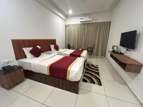 a hotel room with a bed and a television at G K Residency in Mangalore