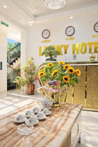 a room with a table with a vase of flowers at Lucky Hotel Uông Bí in Uông Bí