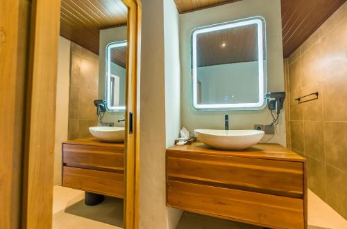 une salle de bain avec deux lavabos et un miroir dans l'établissement Kesumasari Living, à anur