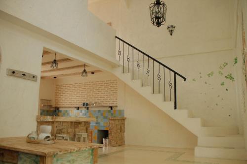 a staircase in a room with a kitchen and a table at M-Apartment in Badung