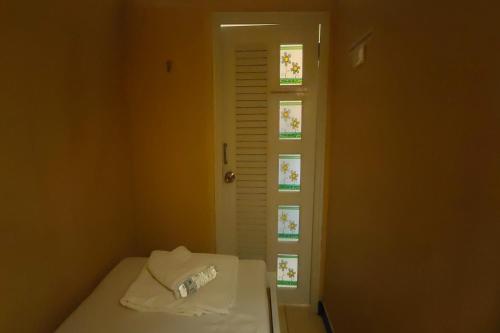 ein kleines Zimmer mit einem Bett und einem Fenster in der Unterkunft Pratunam Family House in Ban Nong Chaeng