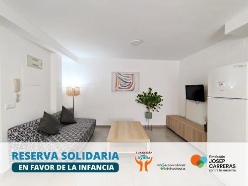 Una sala de estar con un sofá y un refrigerador. en Apartamentos Gandía Centro 3000, en Gandía