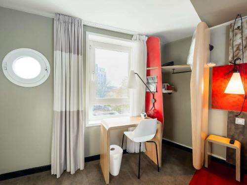 Una pequeña habitación con un escritorio y una ventana. en ibis Portsmouth, en Portsmouth