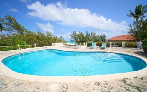 a swimming pool with two blue chairs in a resort at Maltese Falcon - by ZenBreak in Saint Philip