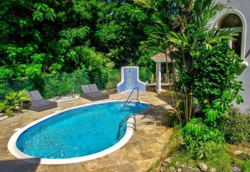 una piscina in un cortile con tavolo e sedie di KingsGate 1 - by ZenBreak a Saint Peter