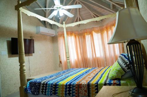 una camera con letto a baldacchino e ventilatore a soffitto di Marzalea - by ZenBreak a Saint James