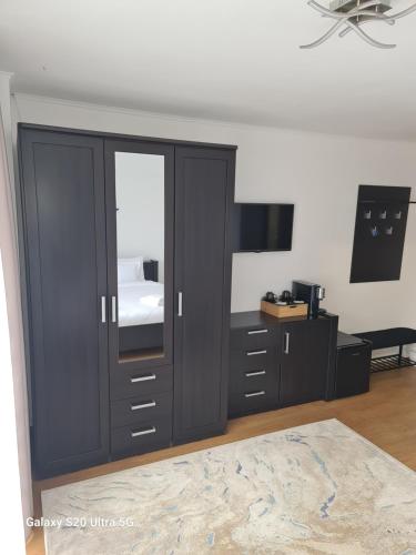 a bedroom with a black cabinet and a mirror at Casa Coresi in Braşov