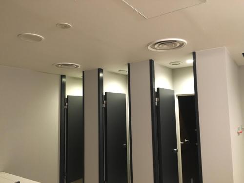 a row of stalls in a bathroom with mirrors at Calendar Hotel in Otsu