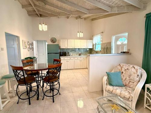 a kitchen and dining room with a table and chairs at Steps to the Sea - by ZenBreak in Saint Peter