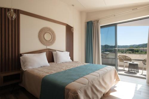 a bedroom with a large bed and a balcony at Sidari Waterpark in Sidari