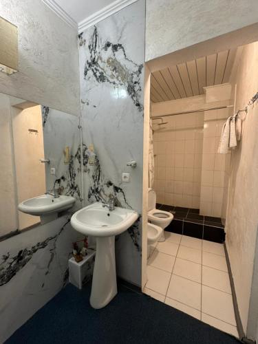 a bathroom with two sinks and a toilet at BT City Hotel in Gornyy Gigant