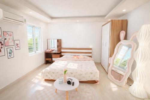 een slaapkamer met een groot bed en een tafel bij Uni Homestay 2 in Hai Phong