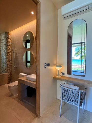 a bathroom with a sink and a toilet and a mirror at Samui Garden Home in Lamai