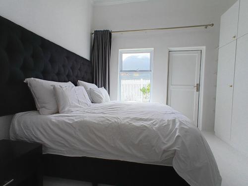 Giường trong phòng chung tại Nirvana Cottage Houtbay