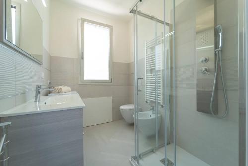 un bagno con doccia, lavandino e WC di Luxi by NG Collection a Olbia