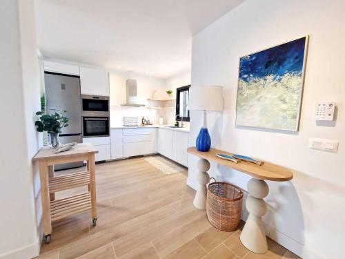 a kitchen with white cabinets and a wooden table at Costa Christina con piscina climatiza in Yaiza