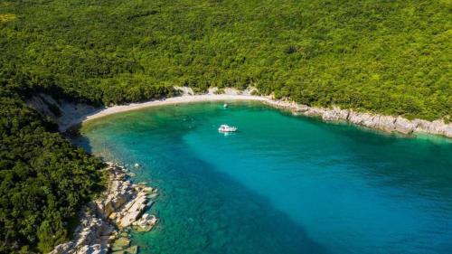 een eiland met een boot in het midden van het water bij Apartments Perci in Krnica