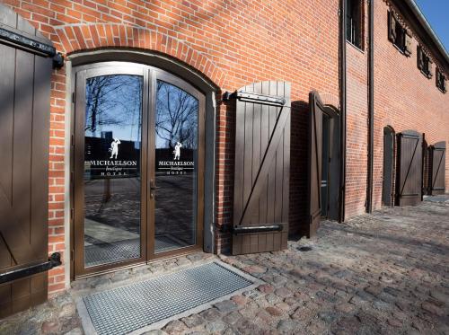 an entrance to a brick building with a revolving door at Michaelson Boutique Hotel & SPA Brícoła in Klaipėda