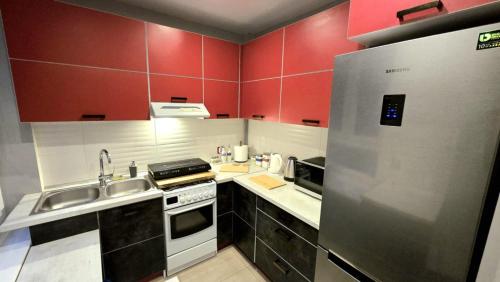 a kitchen with red walls and a stainless steel refrigerator at 4 Lions Guest House in Gdańsk