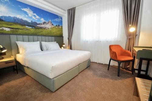 a hotel room with a large bed and a chair at Hotel Aleksandar Conference & Spa in Žabljak
