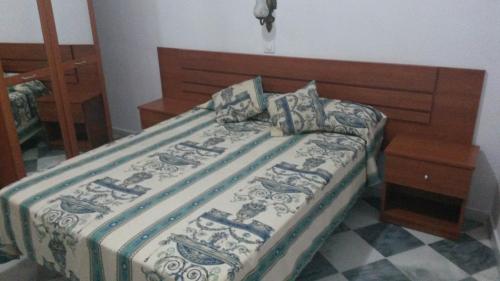 a bedroom with a bed with a wooden head board at Hostal Centro Sol in Cádiz