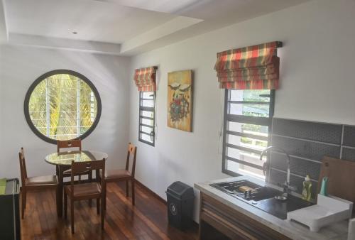 een keuken met een wastafel, een tafel en een raam bij FLORIDA Guest-house in Toamasina