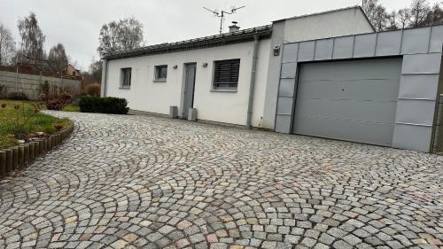 a cobblestone driveway in front of a garage at Apartmán 135 in Trutnov