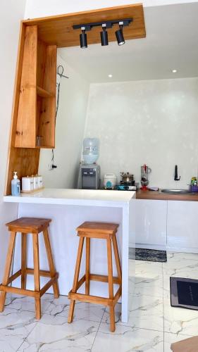 a kitchen with two wooden stools and a counter at Villa Celyn Dieng2 in Diyeng