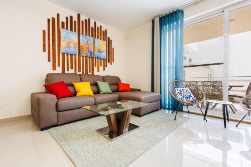 a living room with a couch and a table at Stylish 2BR Retreat, Central Location, Few Steps from the Sea by QuickTrips in Marsaskala