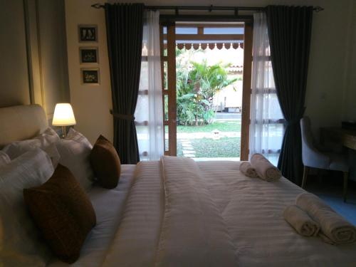 a bedroom with a large white bed with a sliding glass door at Blue Garden Yogyakarta in Yogyakarta
