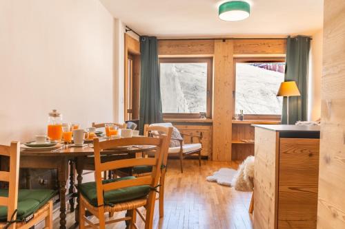een keuken en eetkamer met een tafel en stoelen bij HelloCHALET TrackSide House - Ski-In Ski-Out Apartment on the Cretaz Slopes in Breuil-Cervinia