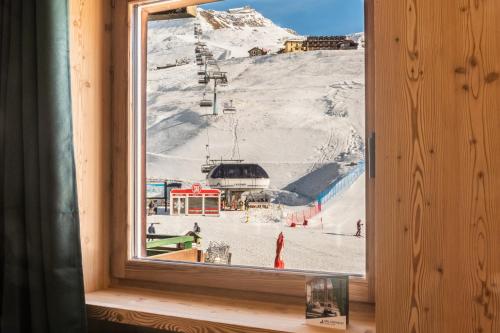 een raam met uitzicht op een skipiste bij HelloCHALET TrackSide House - Ski-In Ski-Out Apartment on the Cretaz Slopes in Breuil-Cervinia