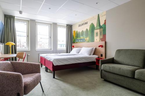 ein Schlafzimmer mit einem Bett, einer Couch und einem Stuhl in der Unterkunft Good Morning Sollentuna in Sollentuna