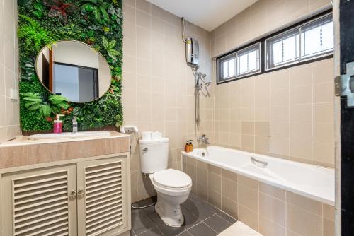 un bagno con un water, un lavandino e uno specchio di Bangkok Cozy Garden Pool Villa Sukhumvit a Amphoe Phra Khanong