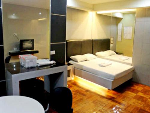 马尼拉Bermuda Hotel的卧室里有一张床，墙上有一面镜子