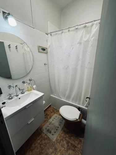 een badkamer met een wastafel, een toilet en een spiegel bij Hospedaje Davolio in Yerba Buena